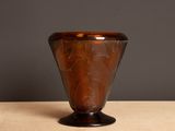 a brown glass vase sitting on a wooden table