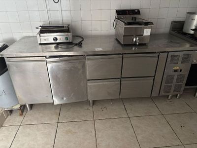une photo d'une cuisine avec des plans de travail et des appareils électroménagers en inox