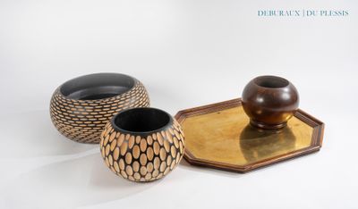 trois vases posés sur un plateau, sur une surface blanche