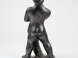 a black statue of a man standing with his back to the camera