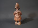 an old wooden figurine of a woman with a turban on her head