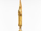 a gold statue of a person holding an umbrella on a pedestal