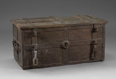 un vieux coffre en bois muni de poignées métalliques, sur fond gris