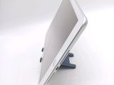 a tablet computer sitting on a stand on a white surface