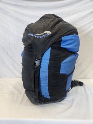 a black and blue backpack sitting on a white surface