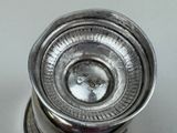 a silver vase with a silver lid on a table
