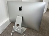 an apple computer sitting on the floor next to a wall
