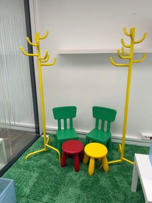 deux chaises et une table dans une pièce recouverte d'une moquette verte