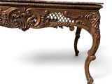 an ornately carved console table on a white background