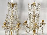 trois chandeliers en cristal sont posés sur une surface blanche