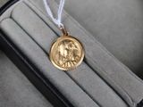 une pièce d'or dans un étui muni d'un cordon blanc