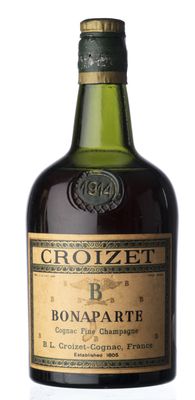 Une vieille bouteille de Crozzer Bonatate est posée sur une surface blanche.