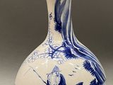 a blue and white vase with a bird on it