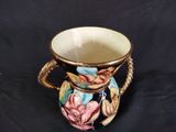 a small vase with a handle on a black background