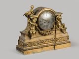 a gold clock sitting on top of a table