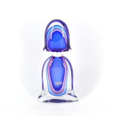 figurine en verre violet et bleu posée sur une surface blanche