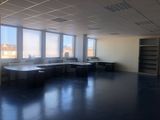 une salle avec de nombreux bureaux et une grande fenêtre