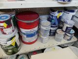 many cans of paint on a shelf in a store