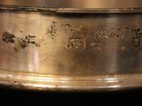 a silver ring with writing on it sitting on a table