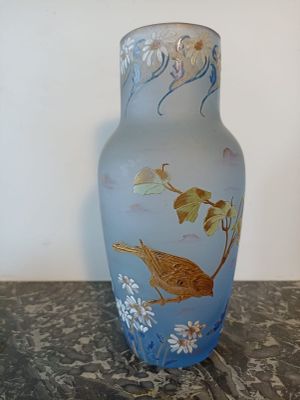 un vase bleu orné d'un oiseau, posé sur une table