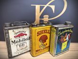 three cans of oil are sitting on a table next to a sign