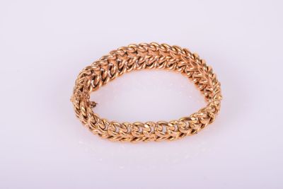 gros plan d'un bracelet en or sur fond blanc