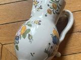 a small white vase with a floral design on it
