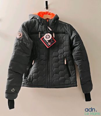the jacket is hanging on the wall with a tag attached to it