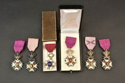 Les trois médailles se trouvent dans un écrin orné d'un ruban rose et d'un ruban violet