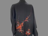 an image of a mannequin dressed in a black suit with red flowers on it