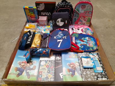 une boîte remplie de fournitures scolaires posée par terre