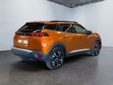 the rear end of an orange nissan c - hr suv parked in a garage