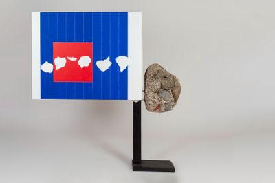 an image of a sculpture of a rock and a piece of paper on a stand