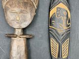 deux masques africains et un couteau posés sur une surface noire
