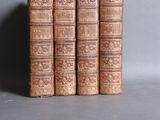 three old books are stacked on top of each other on a table