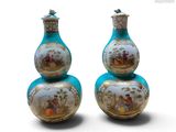 une paire de vases bleus ornés de motifs dorés sur fond blanc