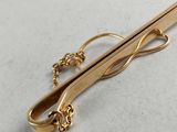 a close up of a pair of gold tie clips on a table