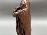 an old wooden statue of a man holding a baby in his arms
