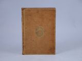 an old brown book with a crest on the front