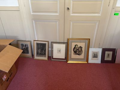 many pictures on the floor of a room with a red carpet
