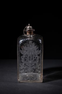 an old glass bottle sitting on top of a black table