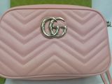 a small pink purse with a metal gg logo on the front