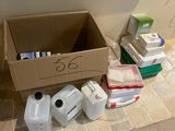 une boîte en carton posée par terre à côté d'un paquet de papier toilette