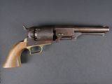 un gros plan d'un revolver posé sur une table, sur fond noir