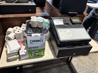 Plusieurs rouleaux de papier toilette sont posés sur une table à côté d'un ordinateur