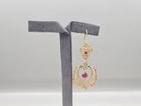 une paire de boucles d'oreilles en or ornées de pierres roses, montées sur un support