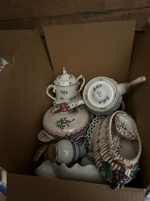 a cardboard box filled with many different types of dishes