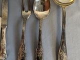 five silver spoons and two silver spoons on a table
