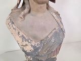 statue of a woman wearing a headdress on a white surface