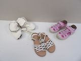 trois paires de sandales et une paire de chaussures posées sur une table